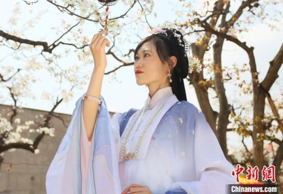 圖為蘭州青年身穿漢服在百年梨園賞景?！「哒?攝