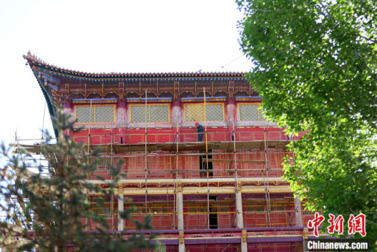 圖為5月上旬，甘肅山丹縣大佛寺內(nèi)，工作人員對(duì)古建筑大雄寶殿進(jìn)行修繕。 中新社記者 高展 攝