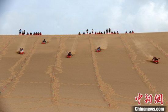 6月13日，敦煌鳴沙山月牙泉景區(qū)舉辦滑沙比賽。　張曉亮 攝