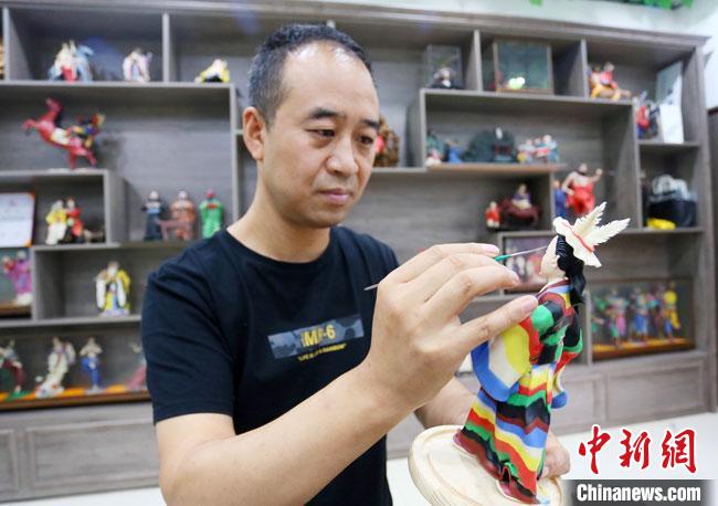圖為安秋平正在創(chuàng)作代表隴南文縣民俗的《白馬人》作品?！「哒?攝