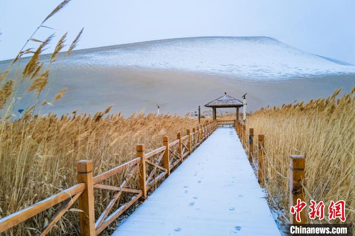 2021年11月28日，在敦煌鳴沙山月牙泉景區(qū)，沙雪交融，更顯北國風(fēng)情?！⊥醣筱y 攝