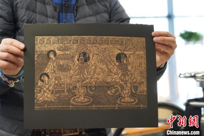 圖為手工書藝人展示敦煌雕版壁畫印刷品?！【琶赖┰?　攝