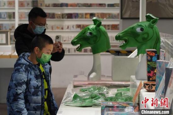 圖為“神馬來(lái)了”銅奔馬頭套吸引參觀者駐足?！【琶赖┰?攝
