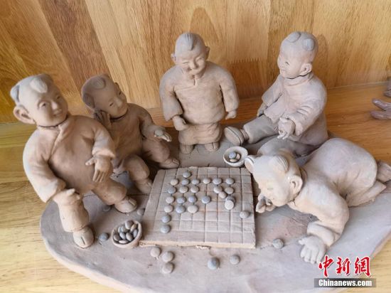 圖為泥塑作品展現下棋場景。 劉玉桃 攝