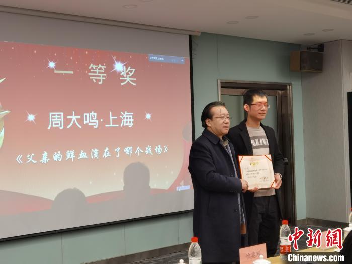 圖為作家、西北師范大學(xué)新聞與傳媒學(xué)院院長徐兆壽頒發(fā)一等獎證書，代領(lǐng)獎?wù)呱吓_領(lǐng)獎?！钅?攝
