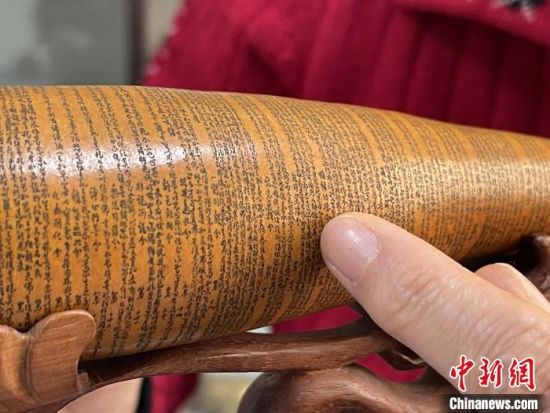 圖為長約二十公分的長條葫蘆雕刻佛教經(jīng)文作品?！堟?攝