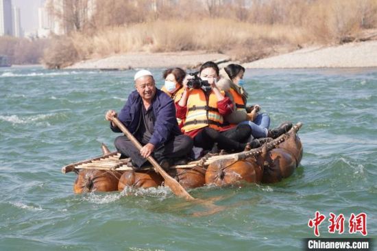 2月24日，年過(guò)七旬的蘭州羊皮筏子制作技藝第三代傳承人張德寶在黃河上劃著羊皮筏子。(資料圖) 九美旦增 攝