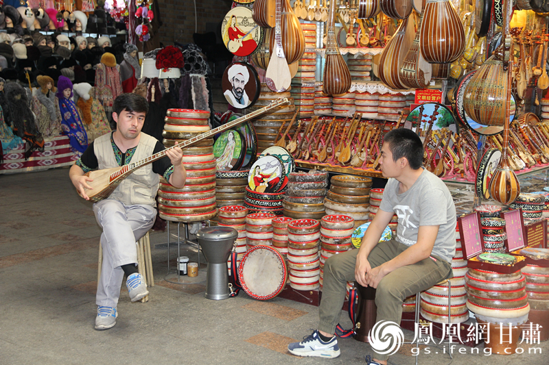 烏魯木齊二道橋巴扎內，店主正在向客人展示樂器。楊文遠 攝