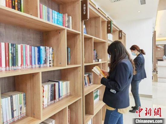 圖為在甘肅公航旅建設(shè)集團(tuán)有限公司的職工書屋，職工挑選書籍。　徐雪 攝