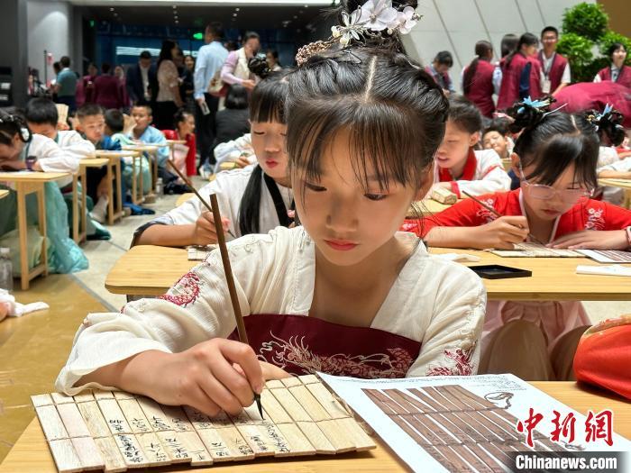 圖為小朋友在甘肅簡牘博物館練習(xí)書法?！≈行律缬浾?戴文昌 攝