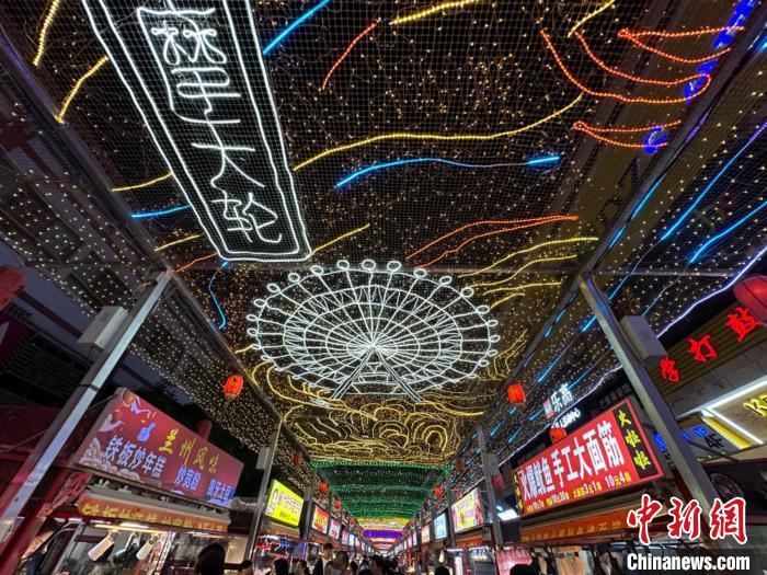 圖為明清街夜市燈光點(diǎn)亮具有武威文化元素的“摩天輪”彩燈。　戴文昌 攝</p><p>