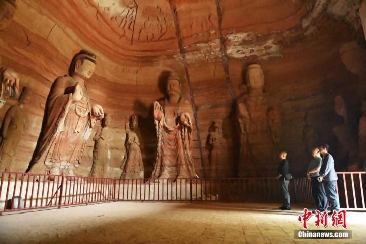 7月15日，游人參觀甘肅省平?jīng)鍪袥艽h百里石窟長(zhǎng)廊中的南石窟寺1號(hào)窟。百里石窟長(zhǎng)廊位于涇川縣境內(nèi)，由512個(gè)石窟、5眼窟中石井組成，現(xiàn)存王母宮石窟、鳳凰山石窟、南石窟寺、丈八寺石窟、羅漢洞石窟、太山寺石窟等規(guī)模較大的石窟群，還有數(shù)量眾多的小石窟群。南石窟寺開鑿于北魏永平三年，其中1號(hào)窟屬于大型七佛窟，七佛高達(dá)6米。中新社記者 李亞龍 攝