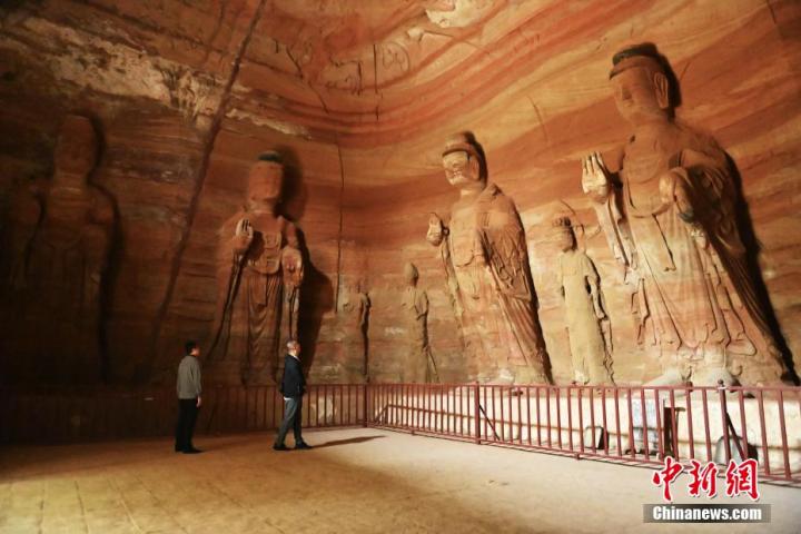 7月15日，游人參觀甘肅省平?jīng)鍪袥艽h百里石窟長(zhǎng)廊中的南石窟寺1號(hào)窟。百里石窟長(zhǎng)廊位于涇川縣境內(nèi)，由512個(gè)石窟、5眼窟中石井組成，現(xiàn)存王母宮石窟、鳳凰山石窟、南石窟寺、丈八寺石窟、羅漢洞石窟、太山寺石窟等規(guī)模較大的石窟群，還有數(shù)量眾多的小石窟群。南石窟寺開鑿于北魏永平三年，其中1號(hào)窟屬于大型七佛窟，七佛高達(dá)6米。中新社記者 李亞龍 攝